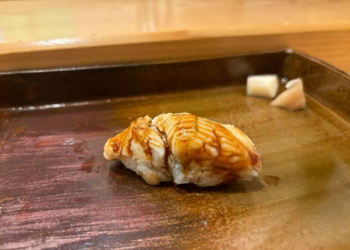 Fresh fish laid on a bed of rice and brushed generously with soy sauce.